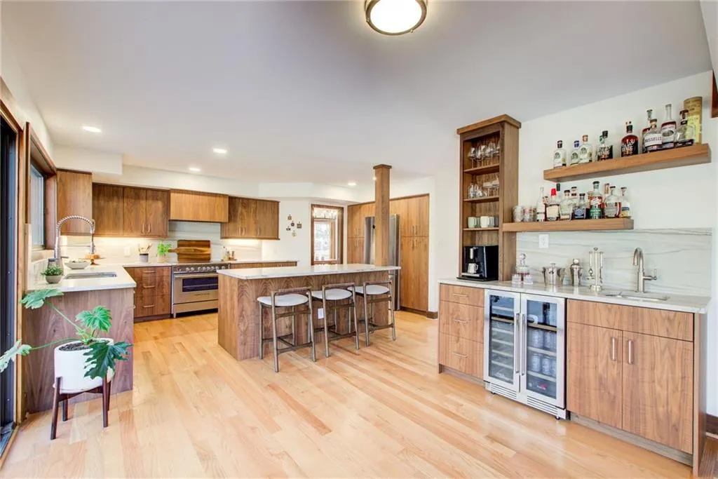 A renovated chef's kitchen and bar with custom  walnut cabinetry