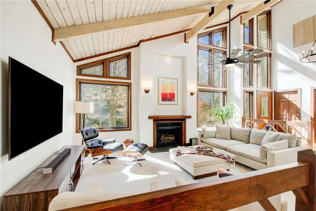Beautiful fireside family room with vaulted, beamed ceilings and walls of windows.