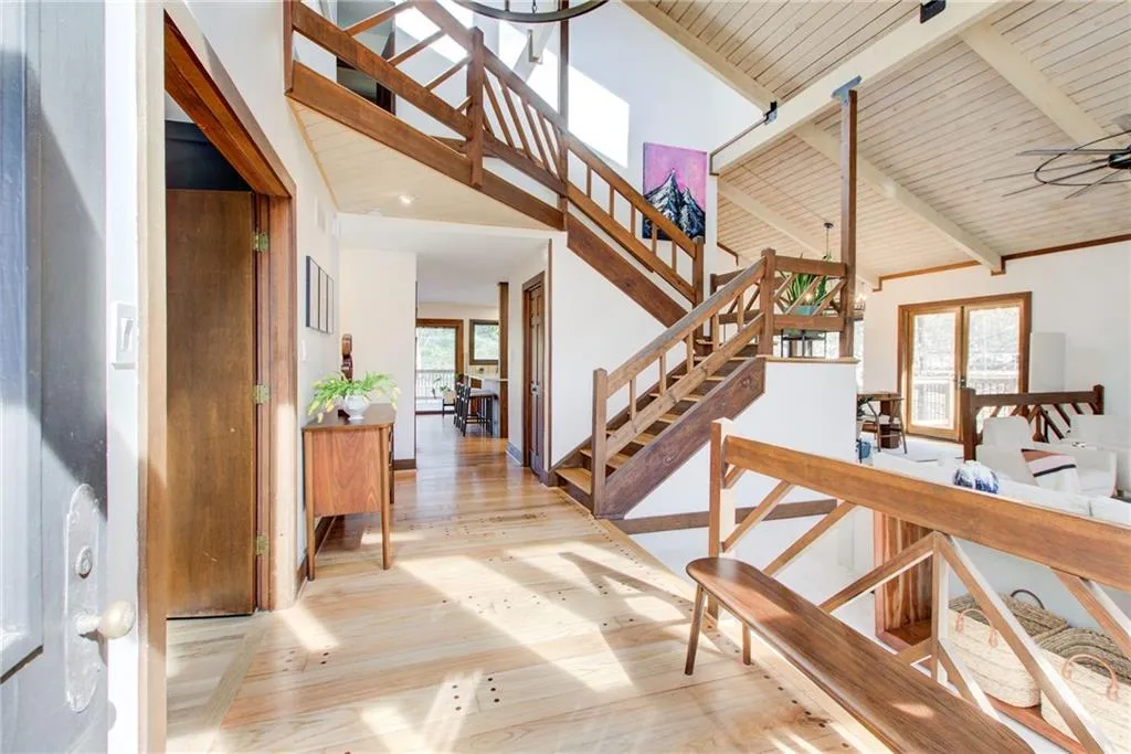 Stairs featuring hard wood  flooring, a high wood beamed ceiling and beautiful wood details throughout the house.