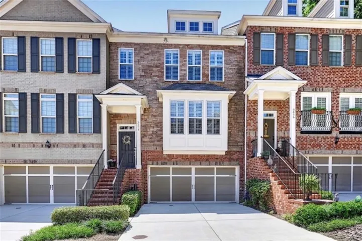 Brick and siding townhome featuring a two-car garage