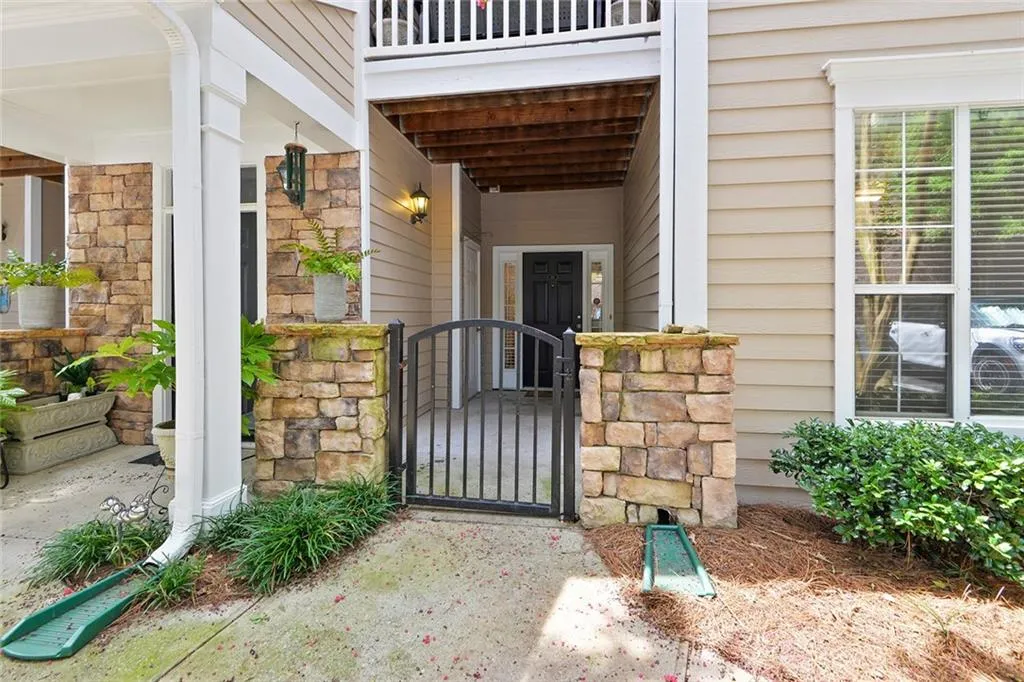 Entrance to property featuring a gate and stone siding