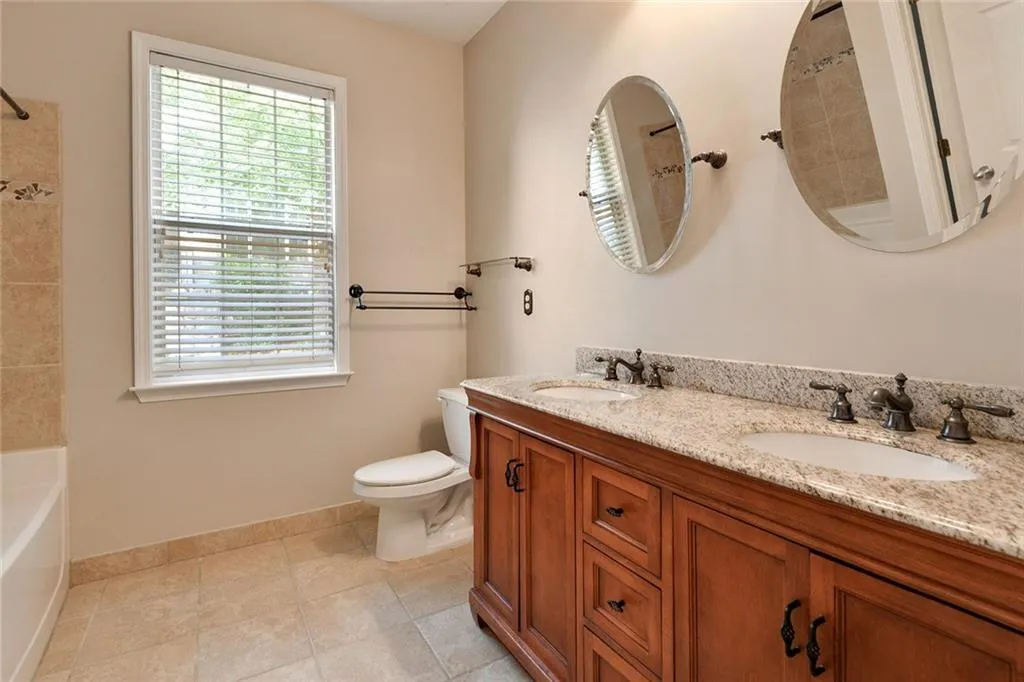 Full bathroom with double vanity and tile patterned floors