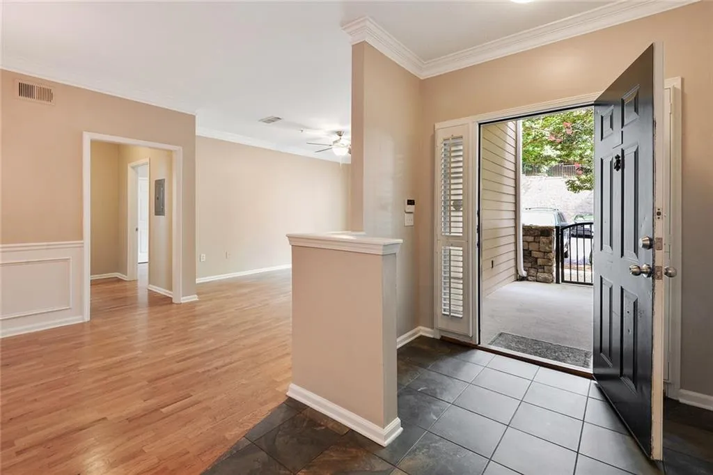 Foyer entrance featuring ornamental molding, a ceiling fan, and wood finished floors