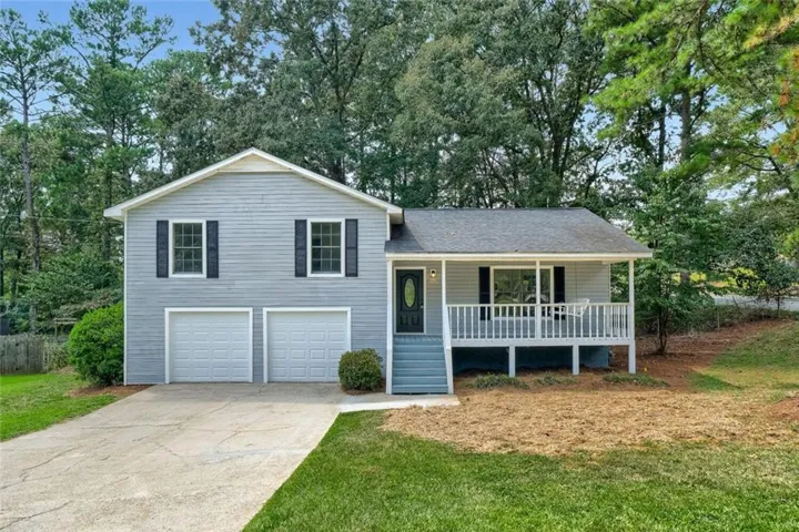Gray siding exterior with a covered front porch, white railing, and dark shutters