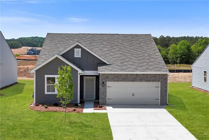 Contemporary home exterior featuring dark gray siding and light brick accents