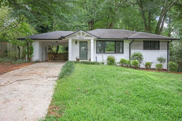Ranch-style exterior featuring white painted brick and grey shingle siding