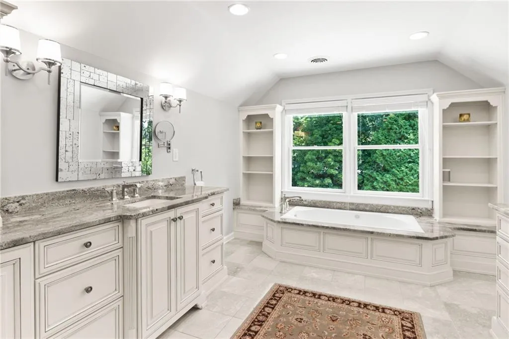 Soaking tub flanked by built-ins.