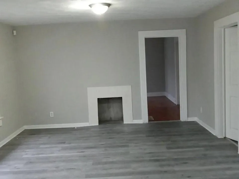 Unfurnished living room with wood finished floors and a fireplace