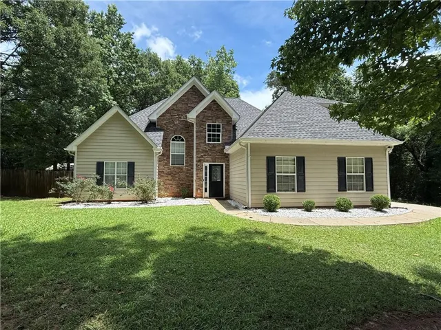 Elegant brick and siding exterior with a peaked roofline and arched entryway