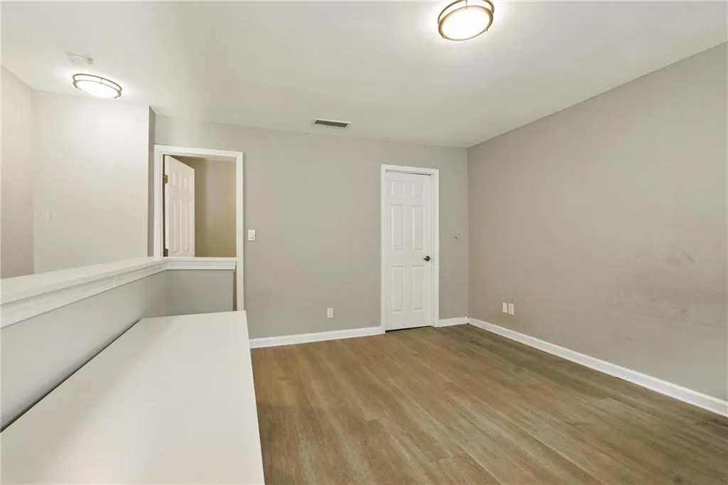 Unfurnished room with light wood finished floors and baseboards