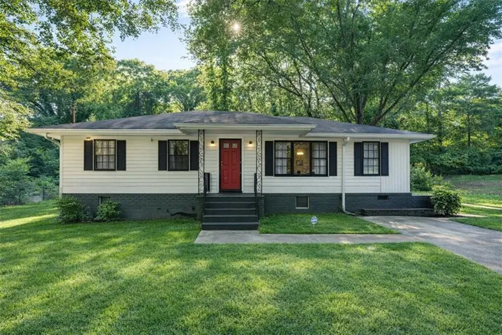 Ranch-style residence featuring a prominent red entry door and black shutters