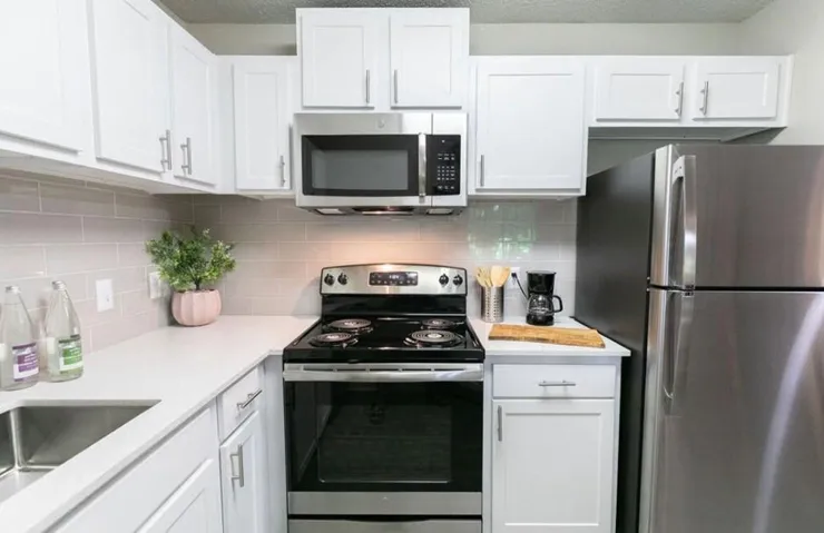 Kitchen featuring appliances with stainless steel finishes and white cabinetry