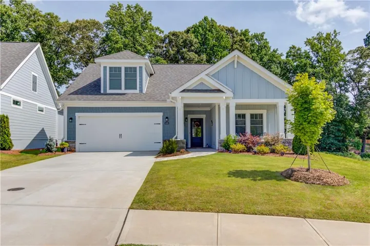Craftsman-style exterior featuring light blue siding, a two-car garage, and a covered front porch