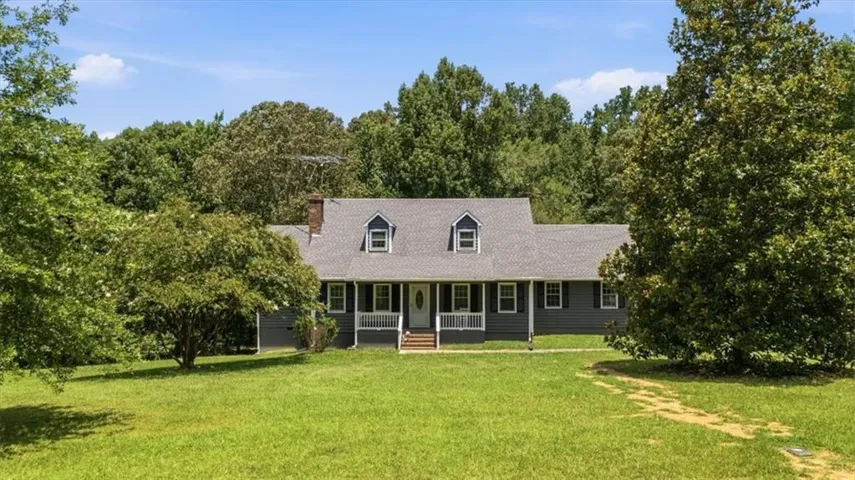 Residence featuring a dark gray exterior, white trim, and a covered front porch with white railings