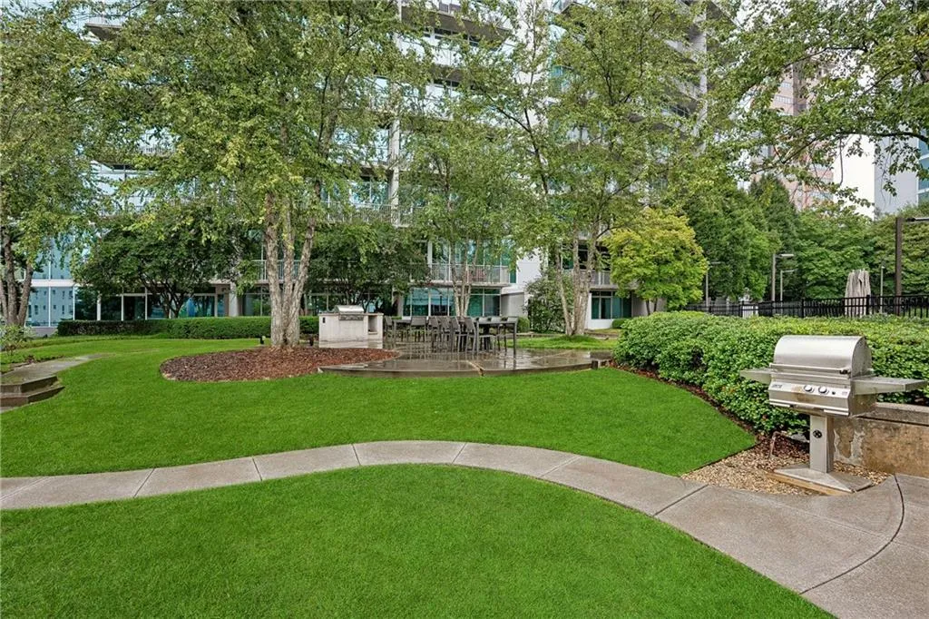View of home's community featuring an outdoor kitchen, a patio area, and a lawn