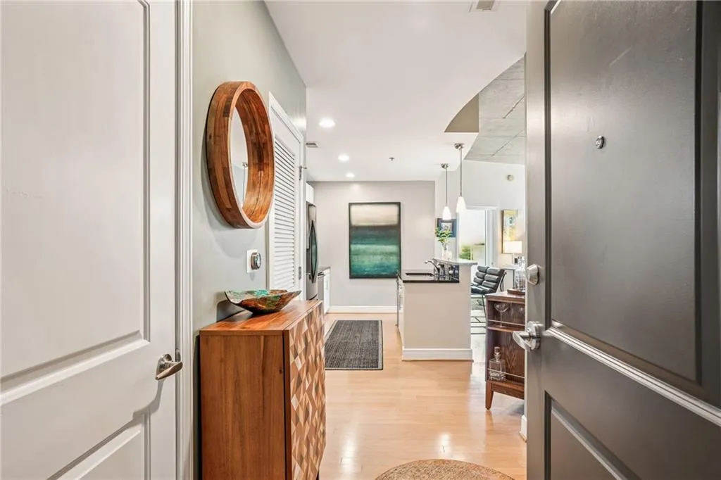 Hall with light wood-style floors and recessed lighting