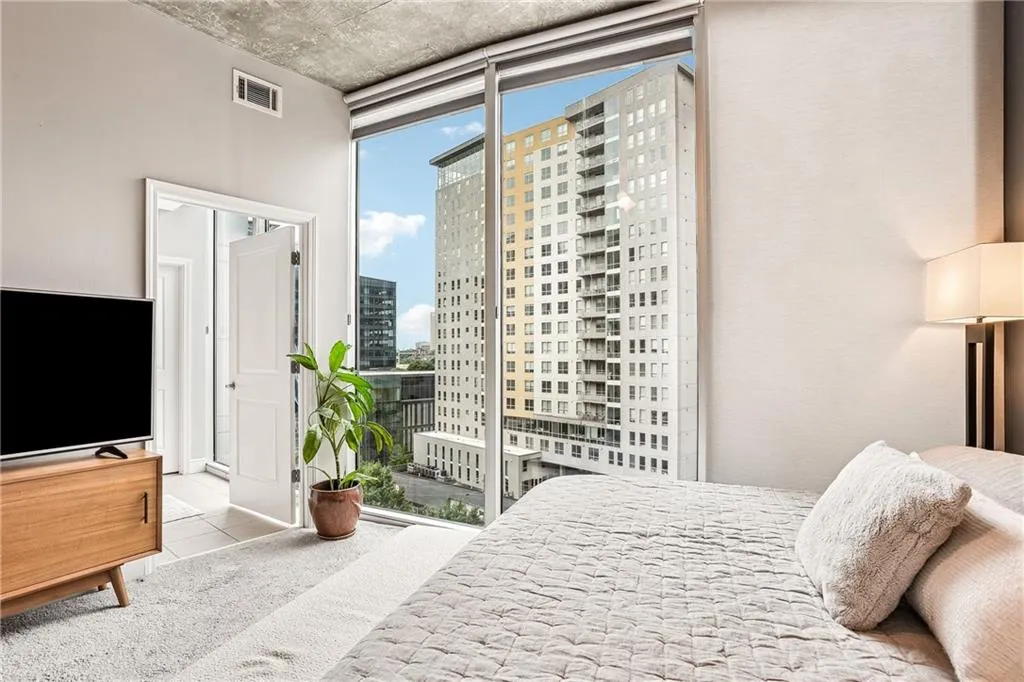 Bedroom featuring a wall of windows, a view of city, and tile patterned floors
