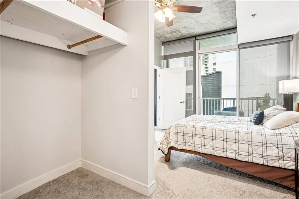 Bedroom featuring light colored carpet, ceiling fan, and access to outside