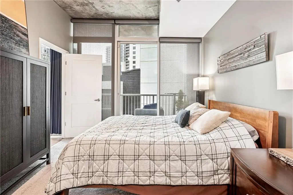 Bedroom featuring multiple windows, a wall of windows, and access to exterior