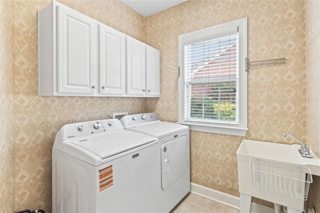 Conveniently located laundry has new appliances, wash tub and storage cabinetry