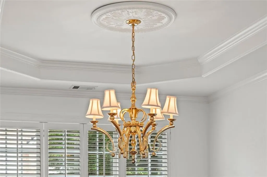 Tray ceiling, crown molding and beautiful chandelier for elegant dining.