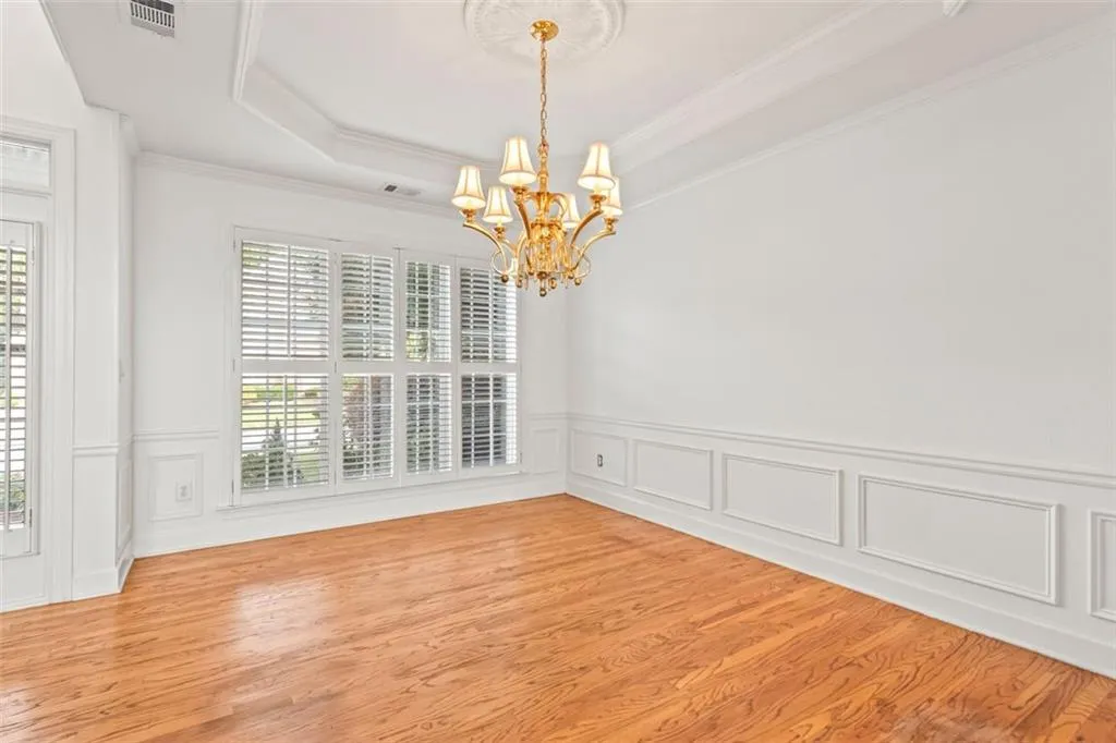 Large picture window, crown moldings and wainscoting elegance