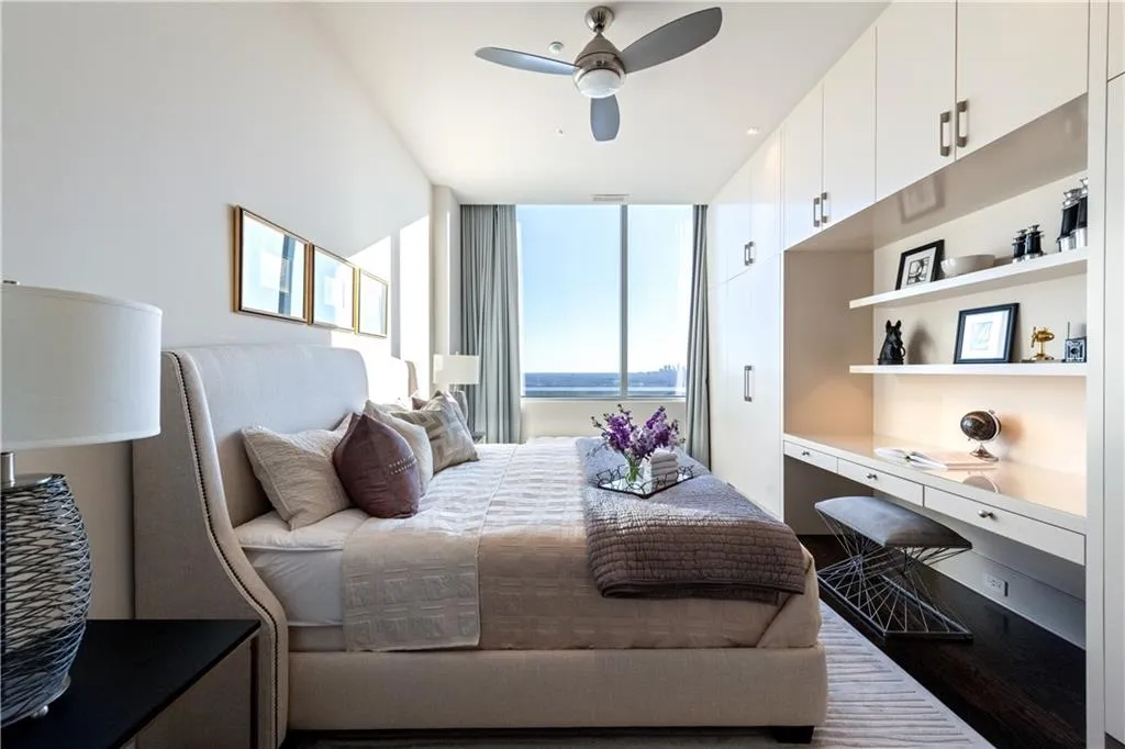 Bedroom with a city view, ceiling fan, hardwood flooring, and built in desk and cabinets