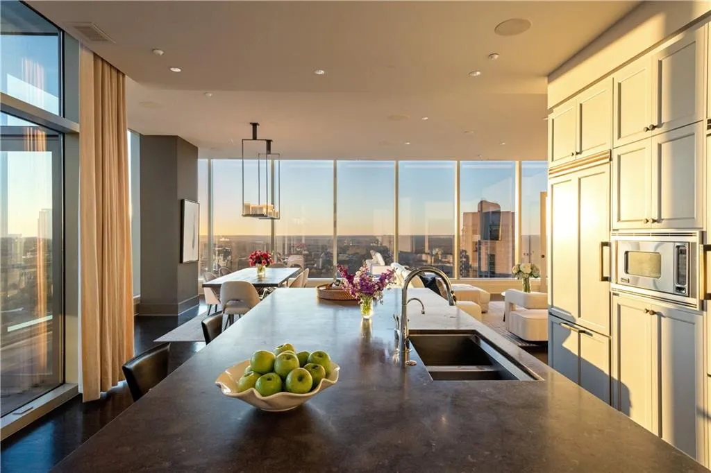 Kitchen featuring sink, a wall of windows, a breakfast bar, and built in appliances