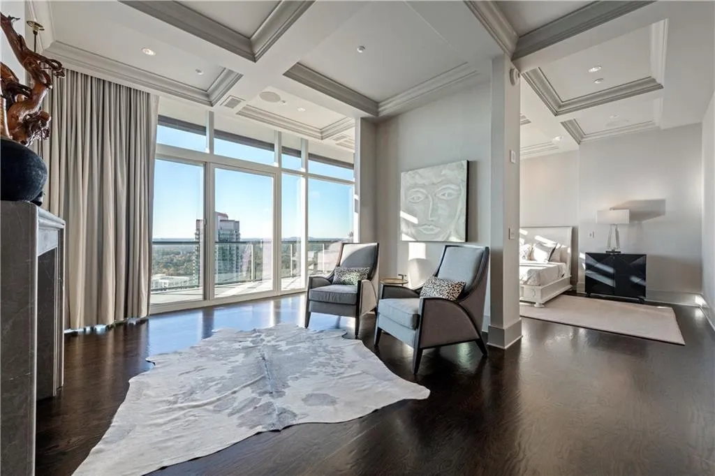 Primary bedroom with a cozy seating area with fireplace and stunning views