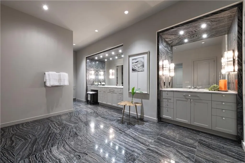Primary bathroom featuring heated floors, towel warmer, walk-in steam shower, and dual vanities