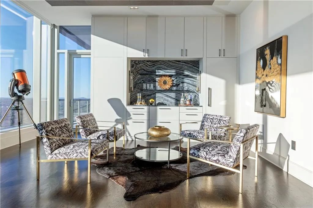 Expansive entertaining area with floor-to-ceiling windows, a stylish bar with a large wine fridge, refrigeration and ice drawer