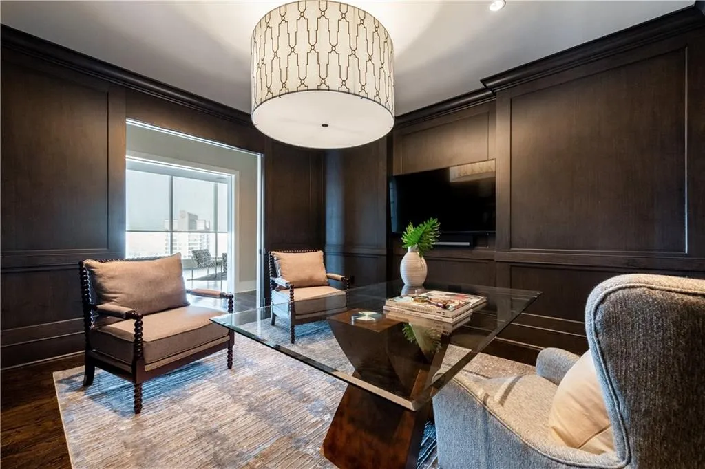 Private office with rich wood-paneled walls, sliding pocket doors offering privacy and stunning skyline views