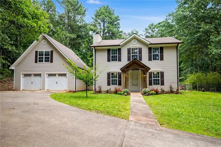 Two-story residence featuring light-toned siding, brown shutters, and a covered entry porch with wood columns
