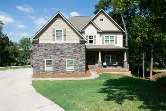 Multi-story residence featuring stone and siding exterior