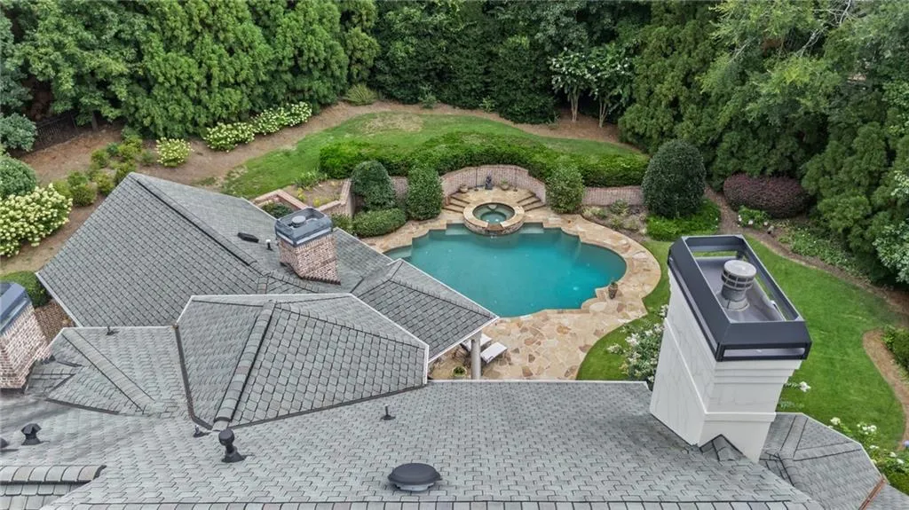 Freeform swimming pool with integrated spa and natural stone coping