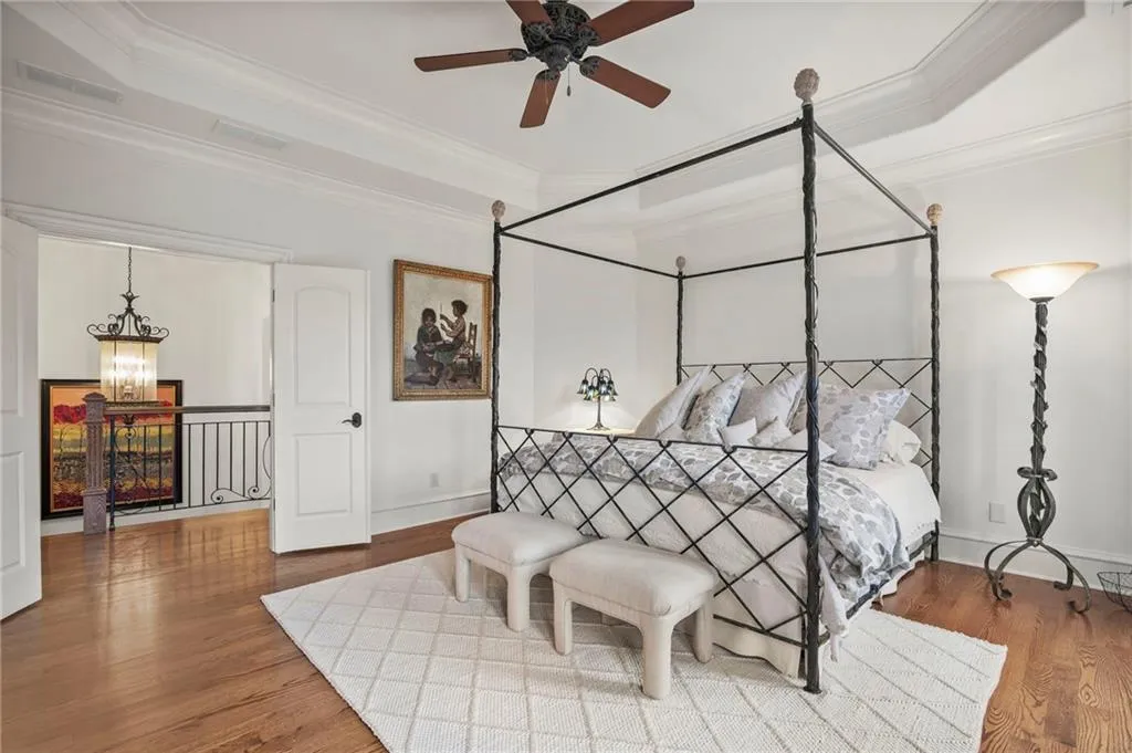 Secondary bedroom 1 with Hardwood flooring, tray ceiling, ceiling fan.