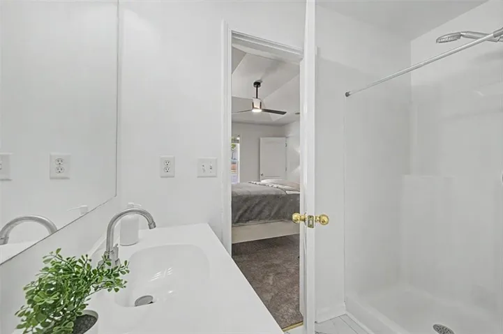 Bathroom vanity featuring an integrated white sink, brushed nickel faucet, and a large wall mirror
