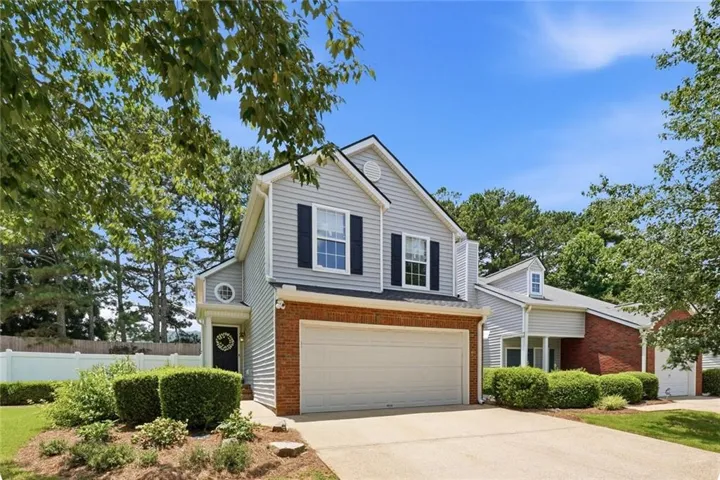 Two-story exterior with light gray siding and brick accents