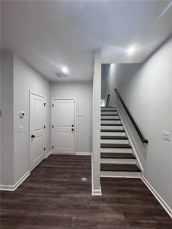 Staircase with baseboards and wood finished floors