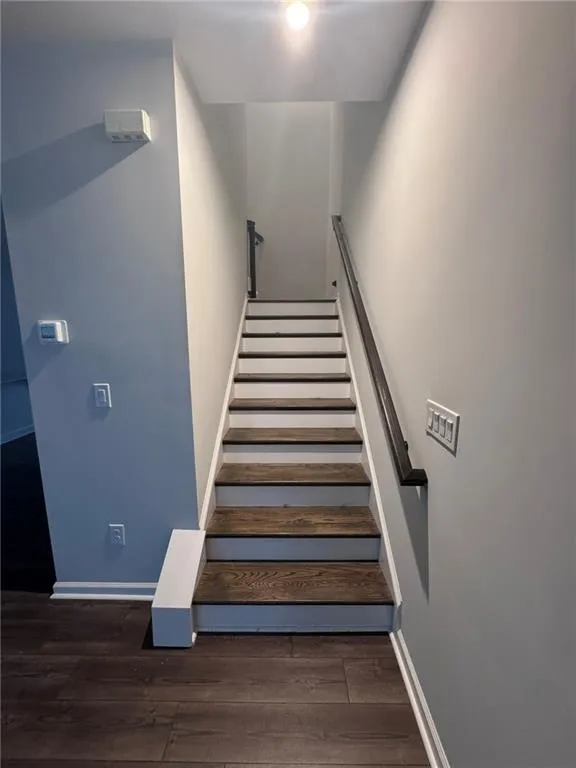 Stairway with baseboards and wood finished floors