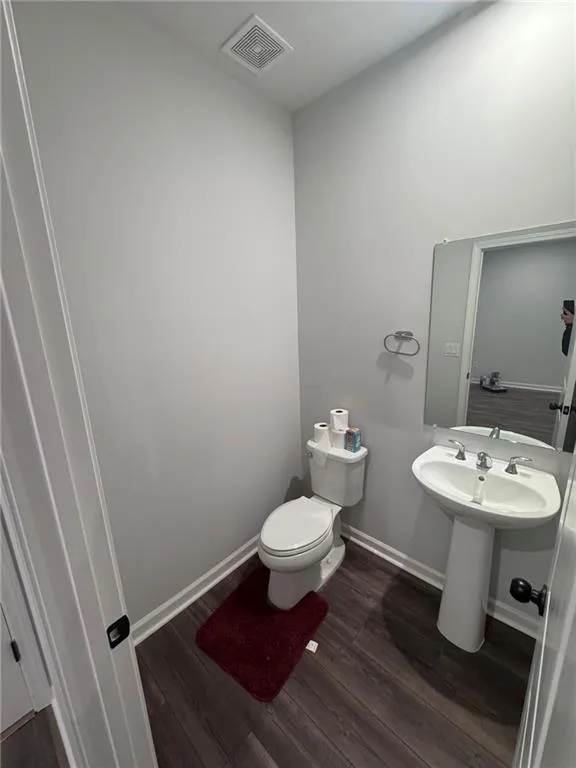 Bathroom featuring baseboards and dark wood-type flooring