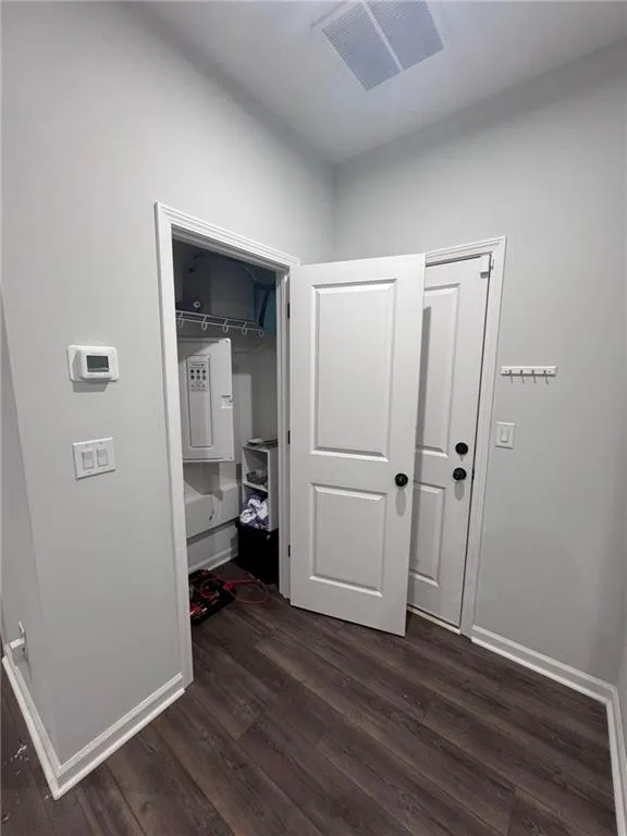 Hallway with dark wood-style flooring and baseboards