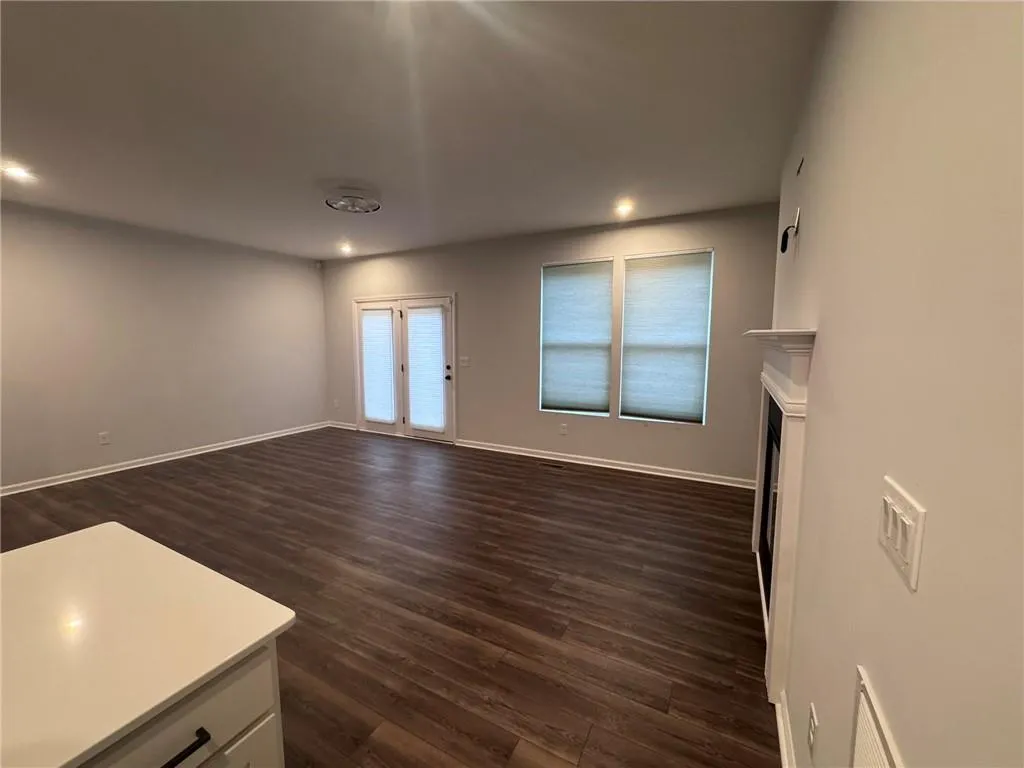 Unfurnished living room featuring a fireplace, dark wood-style flooring, and recessed lighting