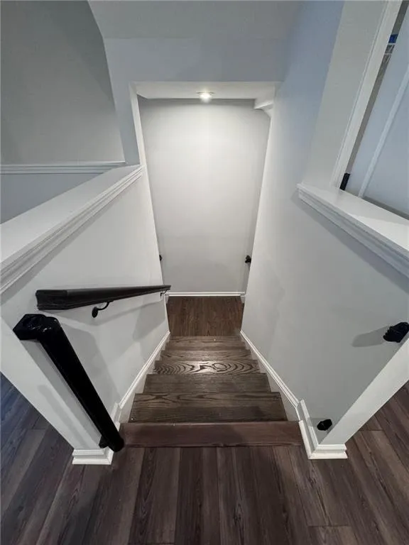 Stairs with wood finished floors and baseboards