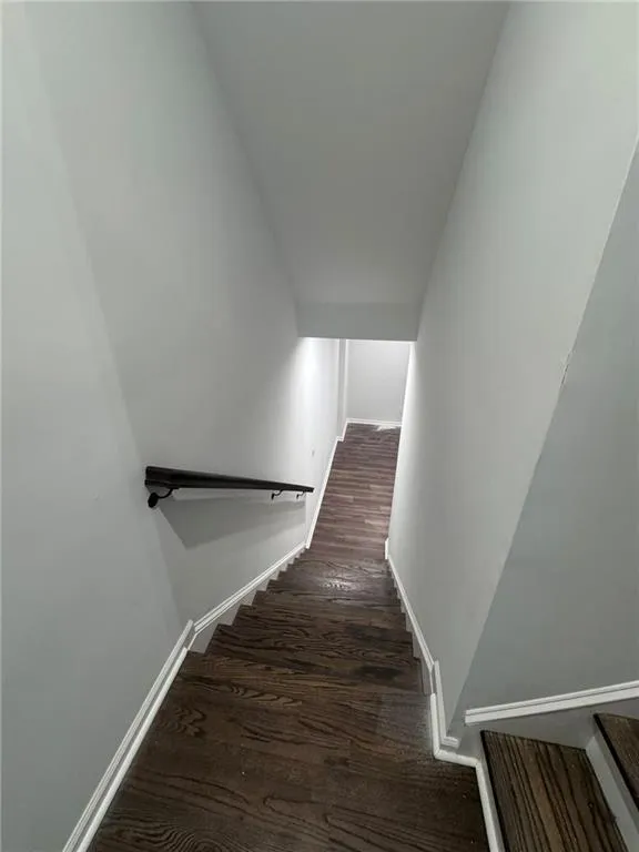 Stairs with wood finished floors and baseboards