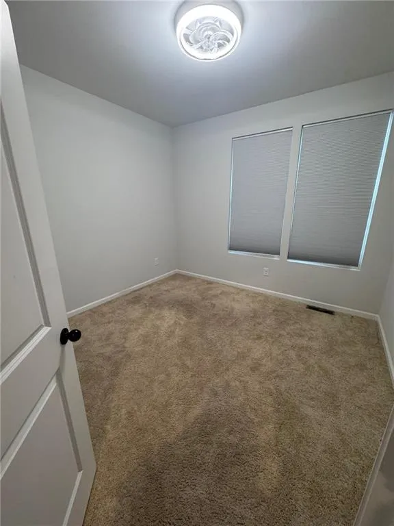 Carpeted spare room with baseboards