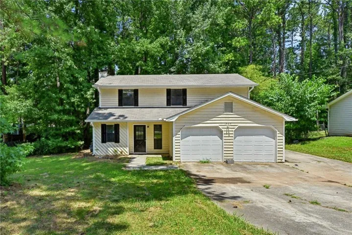 Two-story residence with light-colored siding and dark shutters