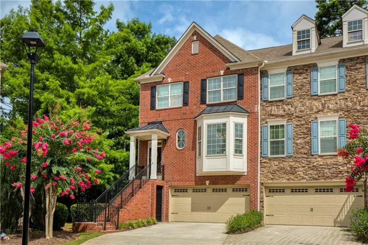 Three-story townhouse featuring brick and stone exterior finishes
