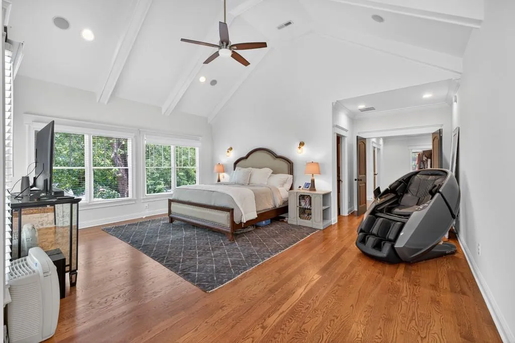 Vaulted ceiling with exposed beams, recessed lighting, wood-finish flooring, and multiple windows