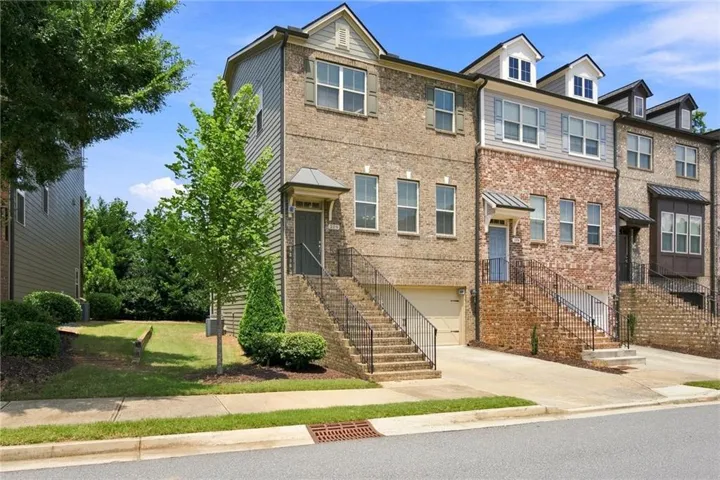 Brick and siding exterior with dormer windows, covered front entry, and attached garage